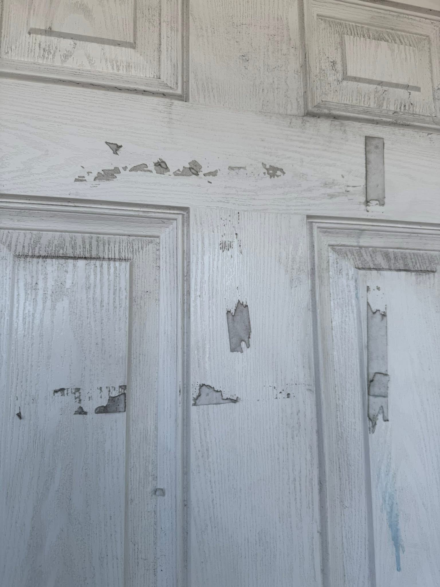 White paneled door with built-up marks before cleaning