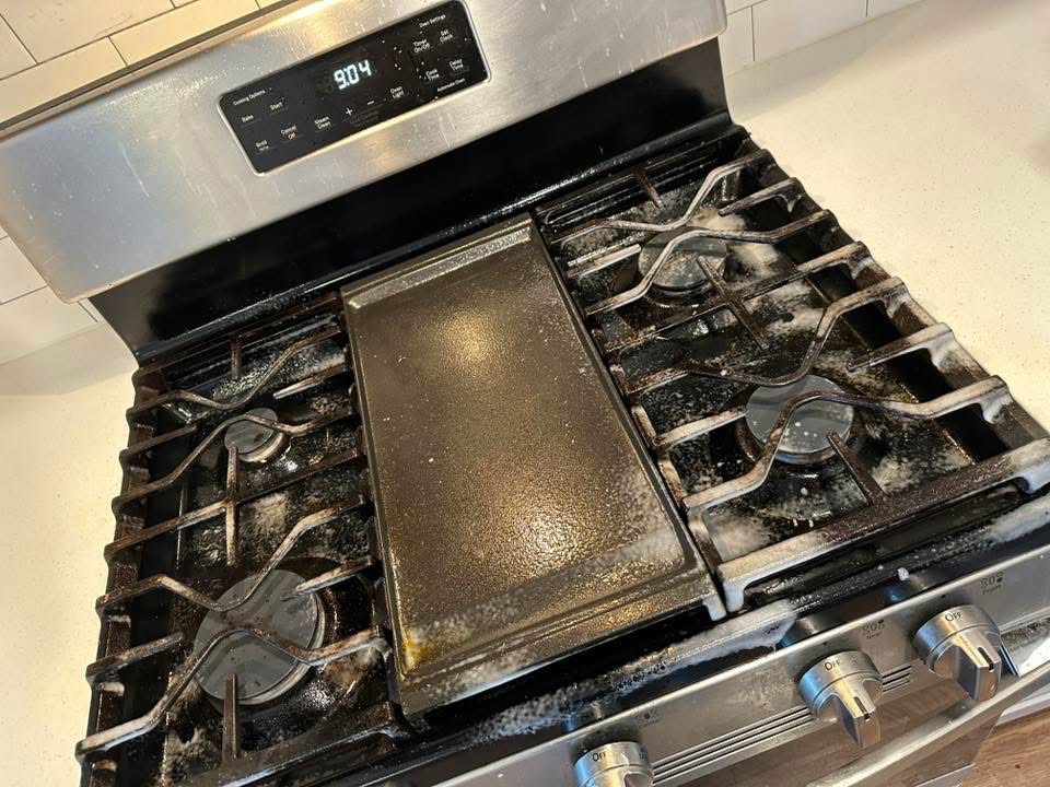 Gas range with cooked-on residue before cleaning